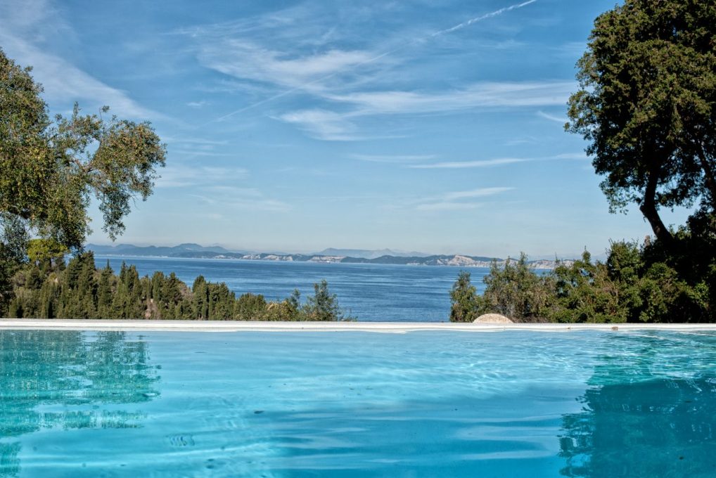 The pool edge at Mistral House meeting the deep blue sea and distant coastline