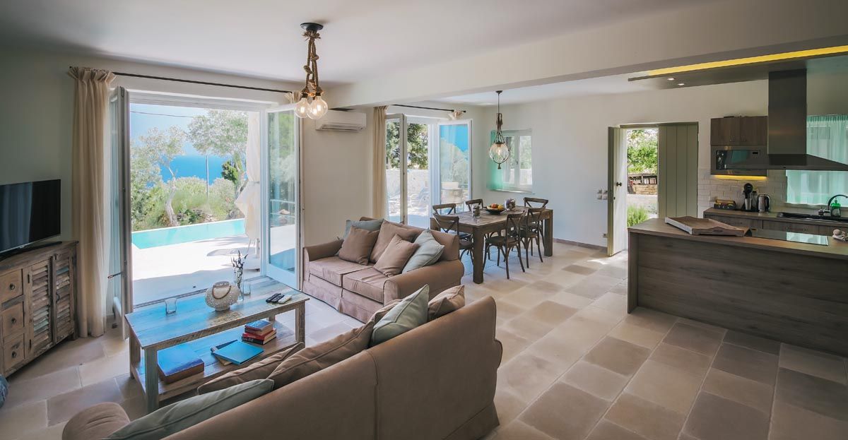 Open-plan living room at Perla House with doors open to the pool terrace