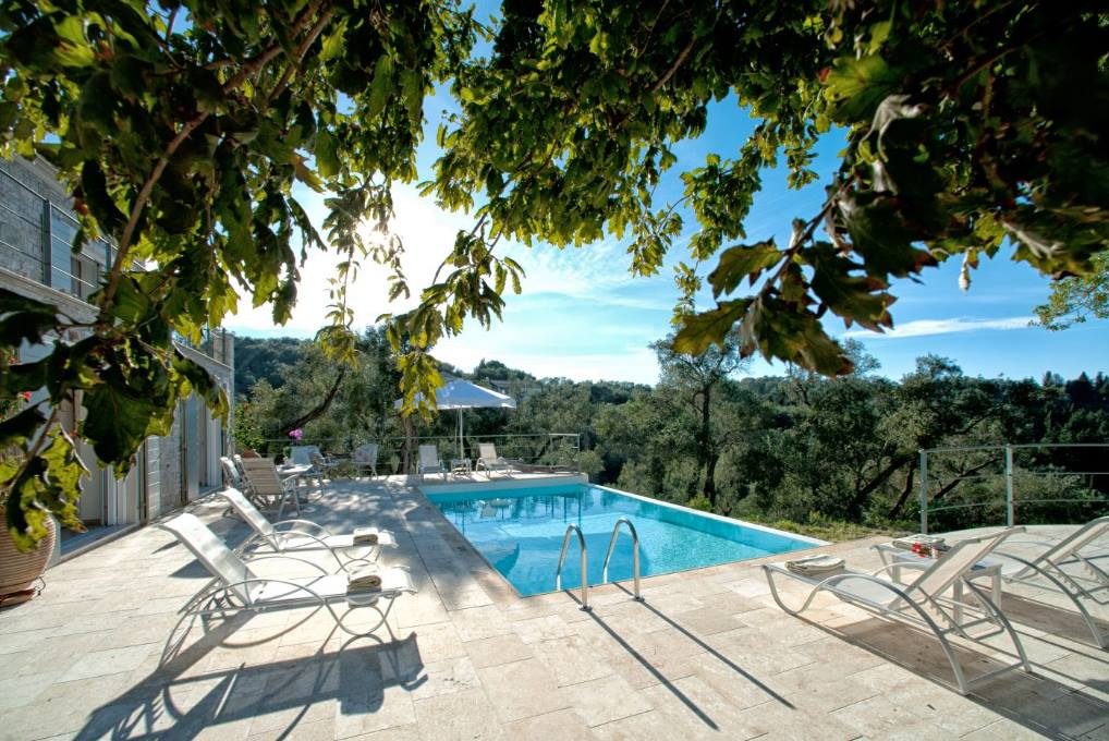 The pool and sun loungers at Mistral House framed by oak branches