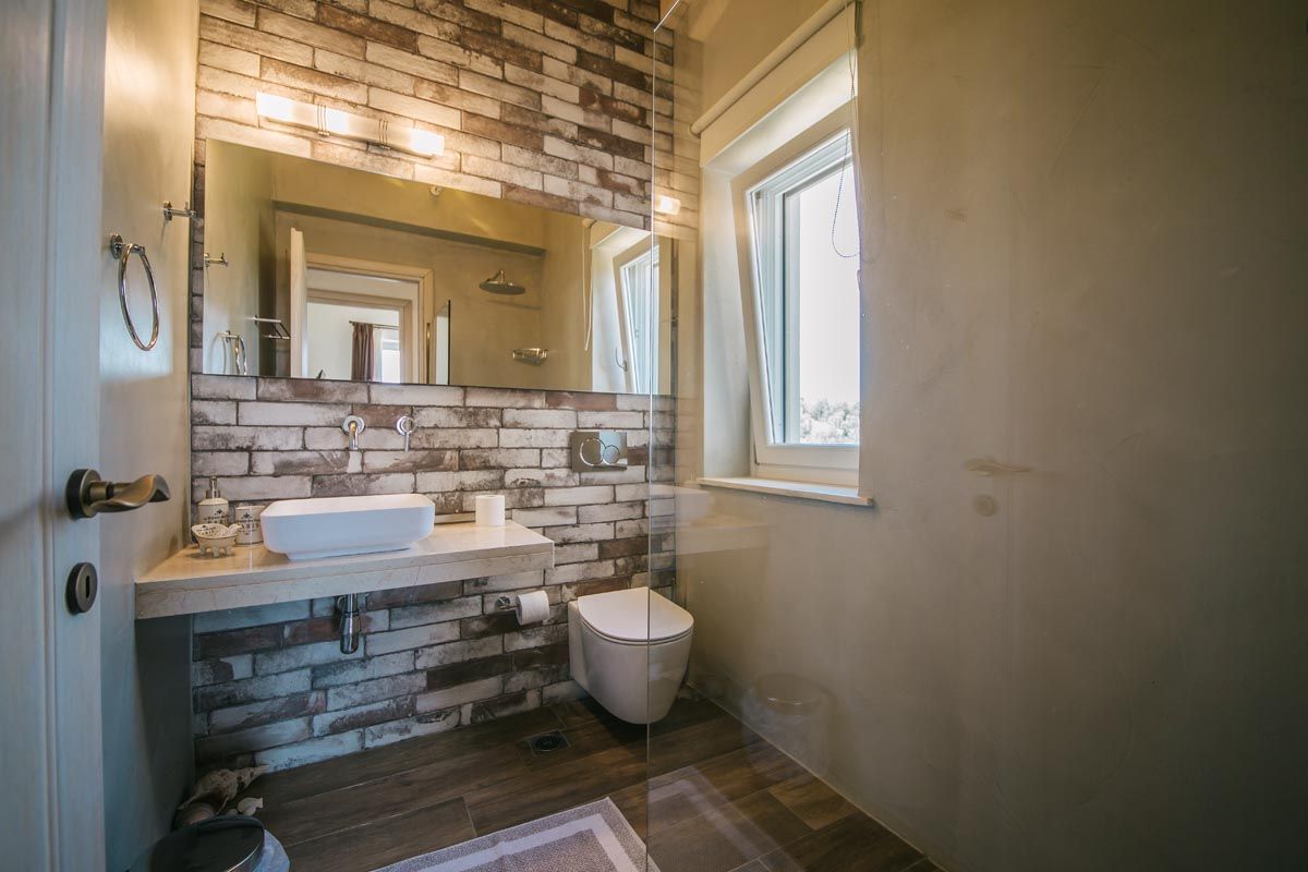 Bathroom at Perla House with a stone wall and walk-in shower