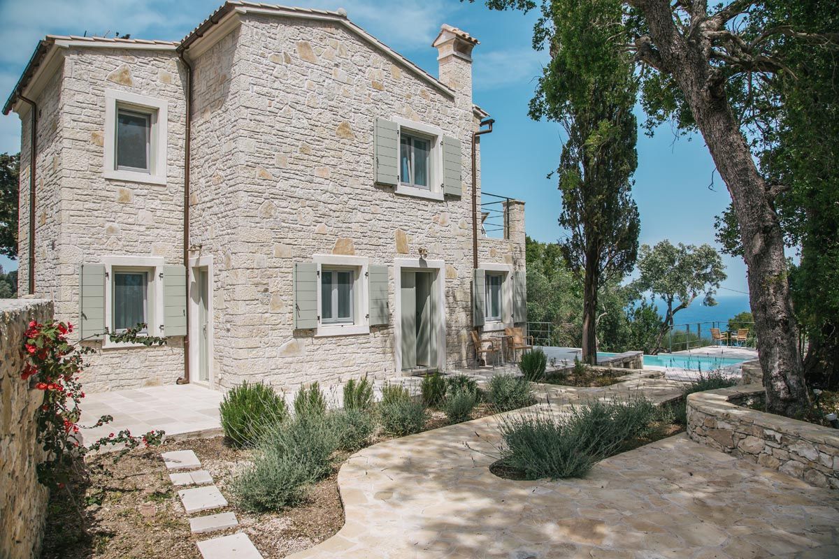 The stone facade of Perla House with lavender and rosemary planting
