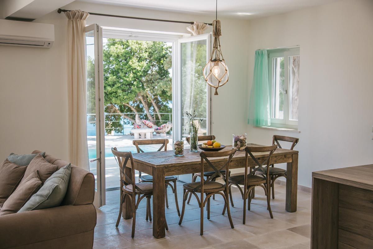 Dining area at Perla House with a timber table and garden light