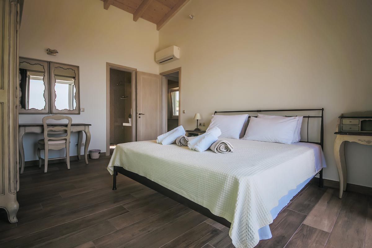 Double bedroom at Perla House with white linen and dark wood floor