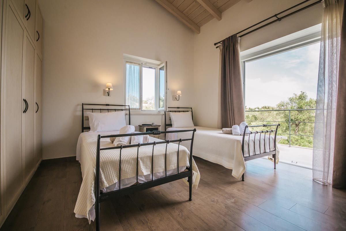 Twin bedroom at Mistral House with iron bedsteads and a garden outlook