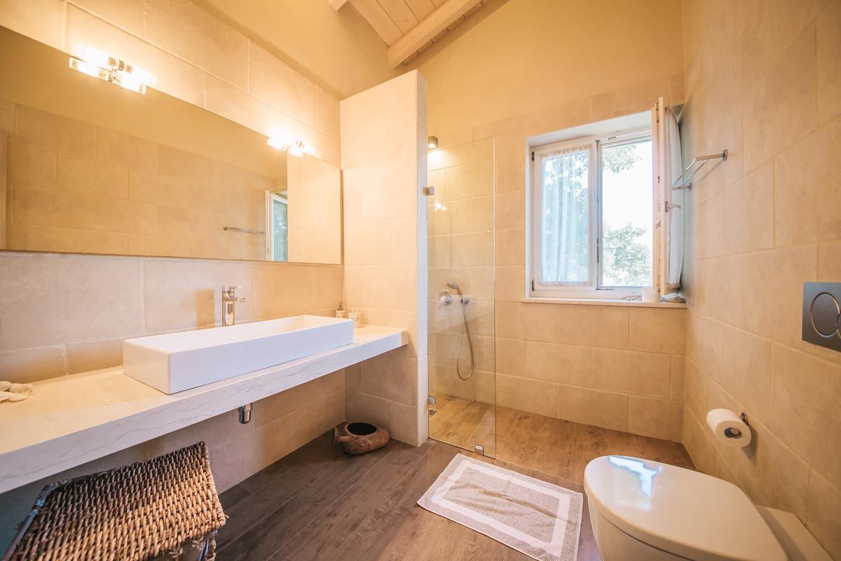 Bathroom at Mistral House with shuttered window and walk-in shower