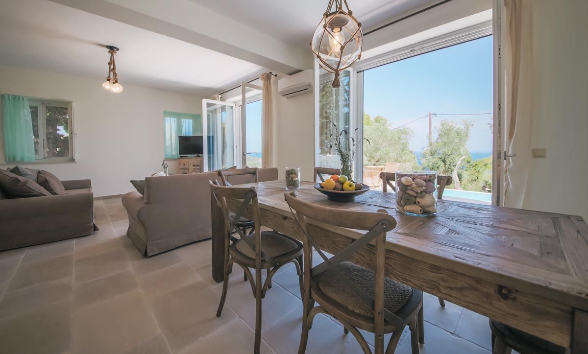 Dining table at Perla House laid for a meal beside the open doors