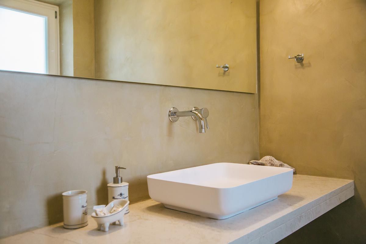 Bathroom at Perla House with a stone-clad wall and basin