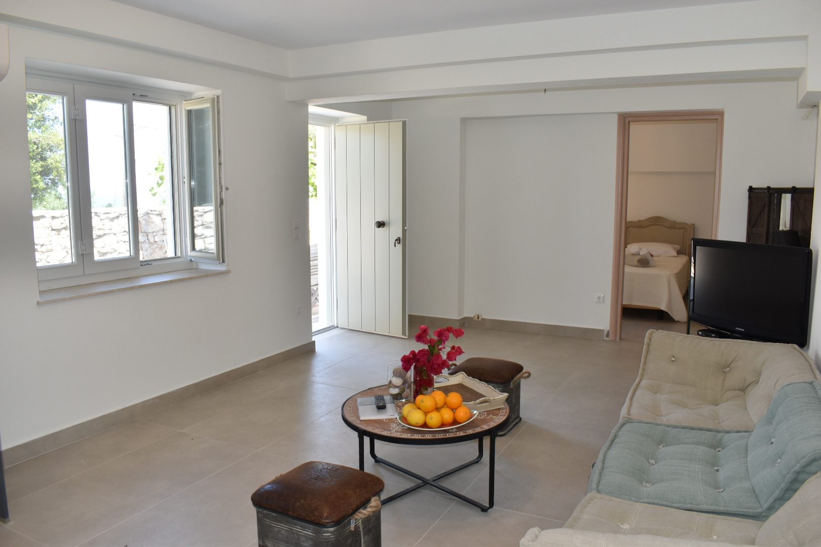 Studio sitting room at Perla House with the door open to the terrace and the bedroom beyond