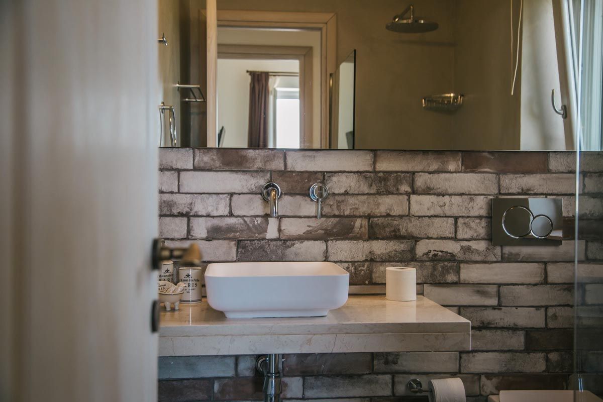 Bathroom at Perla House with a stone feature wall and modern fittings