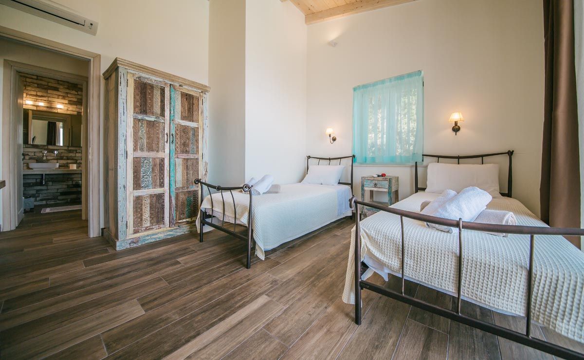 Twin bedroom at Perla House with iron beds and a painted wardrobe