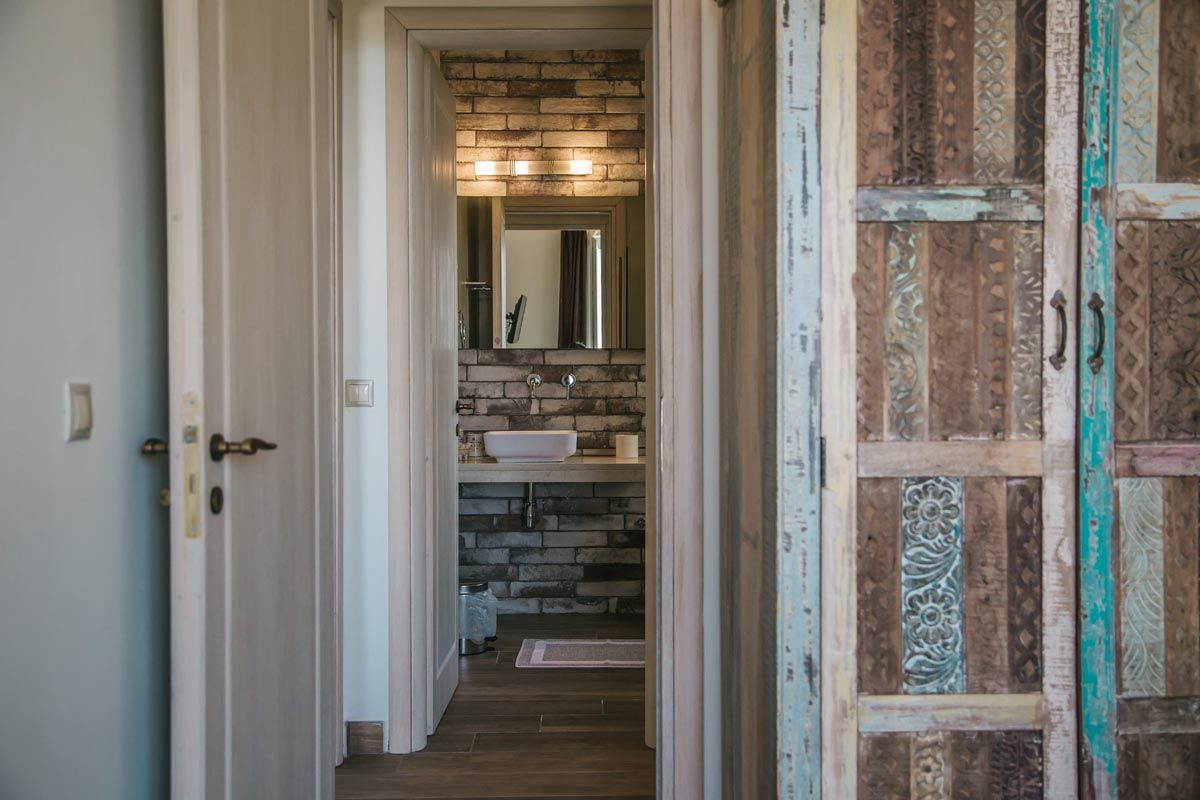 Bathroom at Perla House seen through a painted shutter door