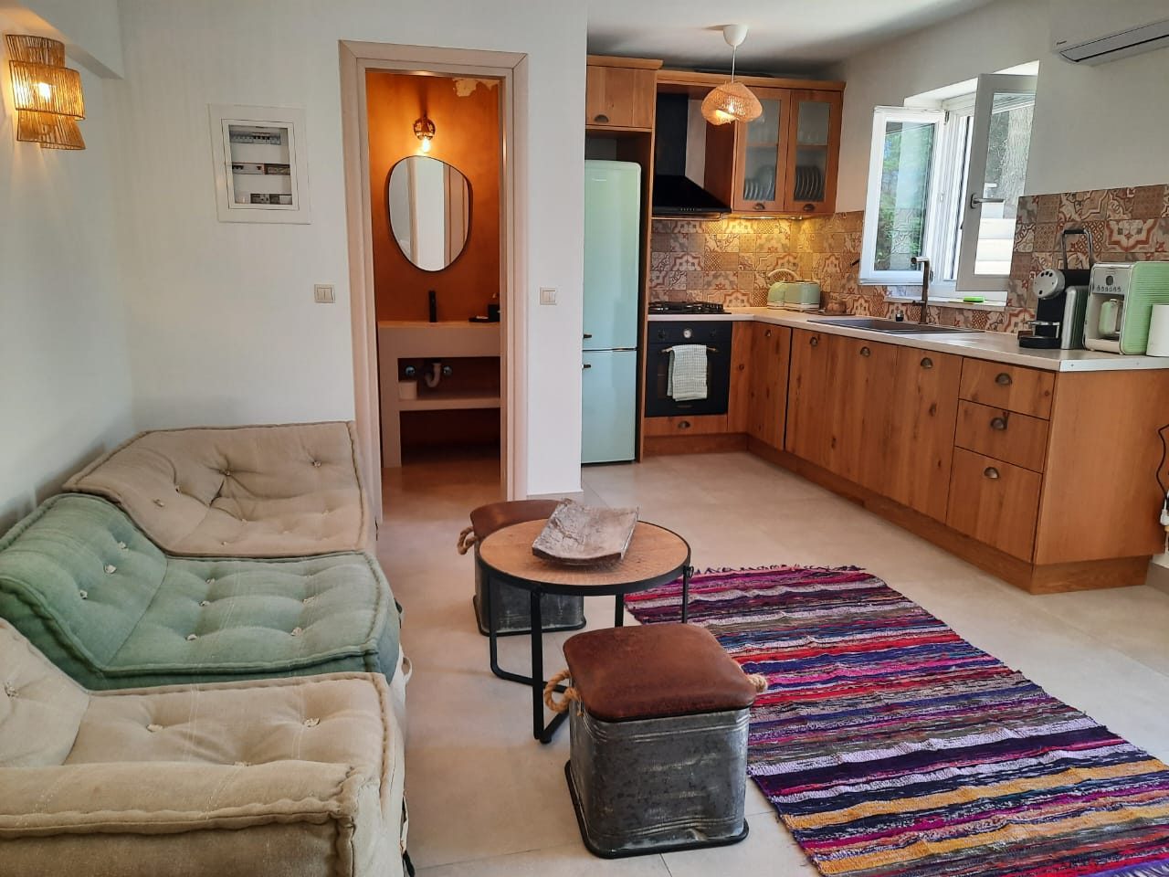 Open-plan studio at Mistral House with its sitting area, kitchen and shower room beyond